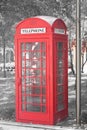 Black and white photo with red telephone booth in classic english style on black and white background in style of black and white Royalty Free Stock Photo