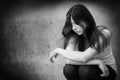 Black and white photo of a sad anonymous girl who is thoughtful about troubles