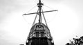 Black and white photo of the scenery of the ship, the stern and the mast on the background of the sky on a summer day.