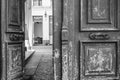 Black and white photo of shabby double door surface with peeling paint. Opened door to patio inside old house in Paris France. Royalty Free Stock Photo