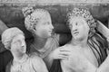 Black and white photo showing in close-up the faces of three ancient sculptures carved on marble