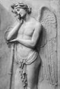 Black and white photo showing beautiful dreamer angel carved on a marble wall