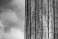 Black And White Photo Of The Skyscraper And A Dramatic Skies Somewhere In London. The Miniature Statue Of Jesus Christ Is Seen In