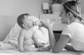 Black and white photo of smiling mother feeding her 9 months old Royalty Free Stock Photo