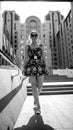 Black and white image of smiling young woman in dress walking down the stone stairs on street at bright sunny day Royalty Free Stock Photo