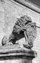 Black and white photo of a statue of a lion holding a historic crest in front of the Mdina gate, the historic Malta capital