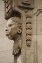 a statue of an old african man on the side of a building