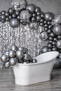 Black and white photo white stylish bathtub in empty room with balloons and confetti