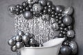 Black and white photo white stylish bathtub in empty room with balloons and confetti