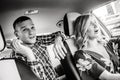 Black and white photo of surprised blonde driver and passenger man in taxi