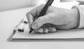 Black and white photo. Take note, female hand holding a pen ready to write something on a blank piece of paper, white Royalty Free Stock Photo