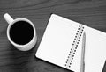 Black and white photo of top view on opened notebook, pen and cup of coffee Royalty Free Stock Photo