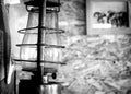 Black and white photo, vintage room, old lamp and hat of cowboy hat on the wall, on the background is picture of horses