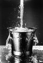 Black and white photo of water falling into bucket