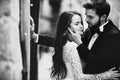 Black and white photo. Wedding couple hugging in the old city. stylish bride in white long dress and groom in suit and bow tie.