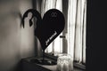 Black and white photo of wedding decoration. Big flat heart with silhouette of wedding couple, wedding rings and