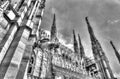 Black and white photo of the white marble statues, spires and stone sculptures on the roof of famous Cathedral Duomo Royalty Free Stock Photo