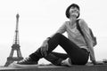 Black and white photo of woman sitting on balcony in front of Eiffel Tower Royalty Free Stock Photo