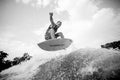 Black and white photo of young active man jumping on the wakeboard down the water against sky Royalty Free Stock Photo