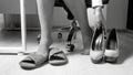Black and white photo of young businesswoman taking of uncomfortable high heels shoes Royalty Free Stock Photo