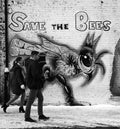 Young couple walks past a Save The Bees wall mural Royalty Free Stock Photo