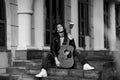 Black and white photo,young, handsome man, brunette with long hair,musician,walking around the city with a guitar, in jeans and a Royalty Free Stock Photo