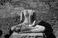 Broken ancient Buddha statue with bricks background