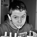 black and white photograph of a child intent on enjoying a nice plate of spaghetti.