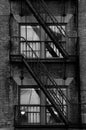 black and white photograph of a fire escape ladder with windows