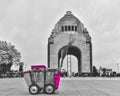 a black and white photograph of a purple cart in front of a monument