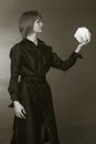 Black and white photograph of a young woman in a black dress, holding in his hand plaster dodecahedron