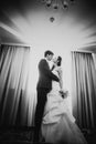 Black white photography beautiful young couple standing near the window Royalty Free Stock Photo