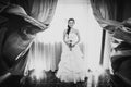 Black white photography beautiful young happy bride standing near the window Royalty Free Stock Photo