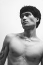 Black and white photography. Portrait of young handsome asian man with tattoo, posing shirtless. Deep serious look away Royalty Free Stock Photo