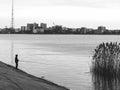 Black and white picture with a fisherman with a rod fishing in Lake Dambovita, in Bucharest, Romania Royalty Free Stock Photo