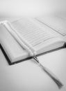 Black and white picture of Quran book and prayer beads isolated in white background