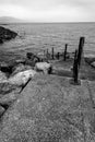 Black and white picture of steps leading down into sea and leading to noewhere Royalty Free Stock Photo