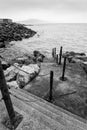 Black and white picture of steps leading down into sea and leading to noewhere Royalty Free Stock Photo