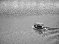 Black and white picture with three man sailors in a motor boat on Vltava river in Prague Royalty Free Stock Photo