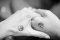 Black and white pictures. Two hands holding each other with yin and yang symbols. Royalty Free Stock Photo