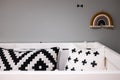 Black and white pillows and rainbow fabric on a wall on a grey decoration bedroom