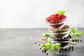 Black, white and pink rose peppers in glass bowls, assorted spices on kitchen table, copy space Royalty Free Stock Photo
