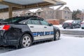 Black and white police car parked in the neighborhood on a snowy and rainy day Royalty Free Stock Photo