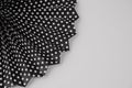 black polka dot print fan with white dots on it on a wall