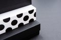 Black and white polka dot gift box on a dark contrasted background, creating a romantic atmosphere. Typically used for birthday, a