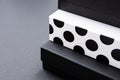 Black and white polka dot gift box on a dark contrasted background, creating a romantic atmosphere. Typically used for birthday, a Royalty Free Stock Photo