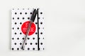 Black and white polka dot note book with red circle  on the cover and black pen on white table. top view, minimal flat lay Royalty Free Stock Photo