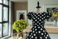 black and white polkadot summer dress on mannequin, in sleek decor