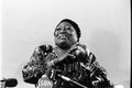 Black and white portrait of actress Esther Rolle with microphones in the foreground