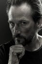 Black and white portrait of a beardy man with serious look on his face.